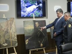 Petro Poroshenko, presidente de Ucrania, mira las pinturas recuperadas. AP / M. Palinchak