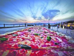 Estilo Margarita, necesitó dos toneladas de harina, dos de mozarella, mil 600 kg. de tomates y 30 de albahaca, y 200 litros de aceite. EFE /