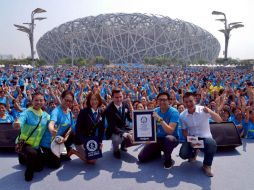 Participantes posaron con representantes de Guinness delante del icónico estadio olímpico conocido como Nido de Pájaro. AP / Chinatopix