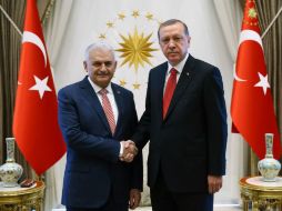 El presidente turco, Recep Tayyip Erdogan, estrecha la mano del primer ministro, Binali Yildirim. AFP / H. Ozer