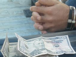 Los hombres tenían consigo varios billetes mexicanos y dólares americanos. ESPECIAL / Policía de Tlaquepaque