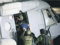 Militares trasladan a Guzmán Loera luego de presentarlo a los medios tras su recaptura en enero de este año. AP /