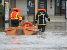 Dos rescatistas empujan una pequeña embarcación, usada para transportar a personas que se quedaron atrapadas en las inundaciones. AFP / K. Tribouillard