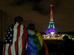 Varias personas se reúnen frente a la torre Eiffel, en la capital francesa, para rendir tributo a las víctimas de Orlando. EFE / Y. Valant