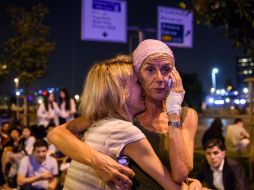 Dos turistas se abrazan afuera de la entrada principal del aeropuerto Ataturk luego del ataque. AFP / O. Kose