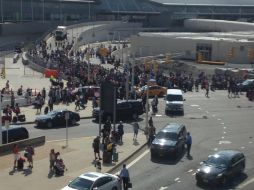 Personas esperan fuera de la terminal 5 del aeropuerto de Nueva York, luego de la alarma policiaca. AP / S. Chase