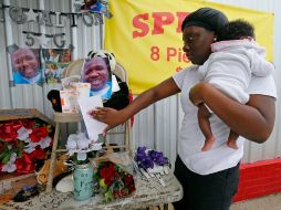 Shermire Reed coloca una tarjeta en el memorial a Alton Sterling, a quien la policía de Baton Rouge mató a tiros la víspera. AP / G. Herbert