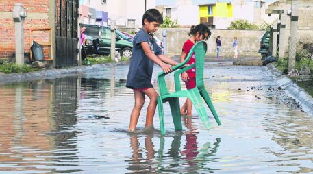 Un niño traslada una silla fuera del agua, en el fraccionamiento residencial El Ángel, en la colonia La Azucena, en El Salto. ESPECIAL /