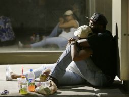 Personas esperan para poder regresar a sus autos, mientras la policía investiga la zona del tiroteo. AP / M. Mulligan