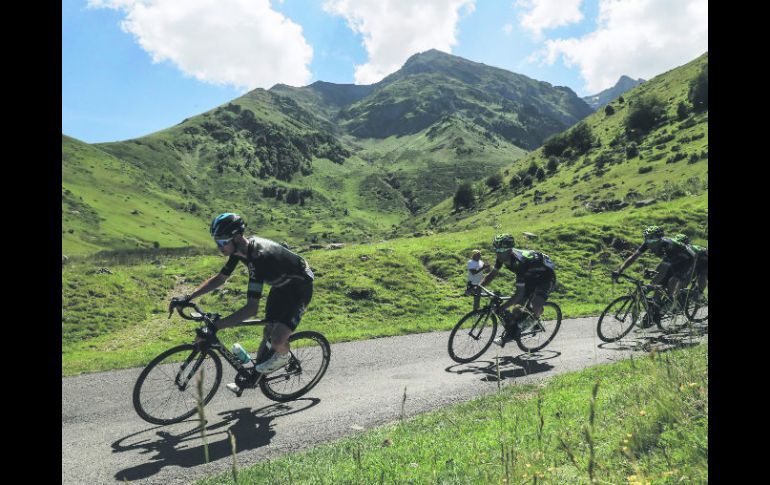 Agachado encima del manubrio y pegado al tubo superior de su bicicleta, el británico emprendió un arriesgado ataque cuesta bajo. AFP /