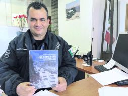 El oficial José Julio Arizaga Rodarte muestra el libro en el que narra la conformación de la Comisaría de Guadalajara. ESPECIAL /