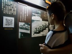 Un pequeño observa varias fotografías que documentan lo ocurrido en 1989. AFP / A. Wallace