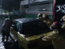 Personal de Protección Civil y Bomberos ayudan a conductores de autos varados tras la tormenta. EL INFORMADOR /