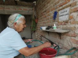 Un chorro de felicidad. Teresa Espinoza, vecina de la colonia Emiliano Zapata, tenía que usar una manguera para llevar agua a su casa. EL INFORMADOR / F. Atilano