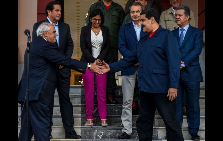 El presidente Nicolás Maduro (der) y Ernesto Samper (izq) se dan la mano luego de la inclusión de El Vaticano. AFP / J. Barreto