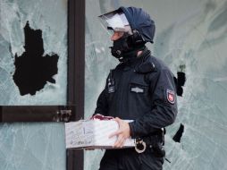 Un oficial de la Policía alemana sostiene una caja con varios documentos confiscados. EFE / J. Stratenschulte