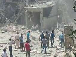 Personas se reúnen alrededor de un hospital materno infantil dañado por los ataques. AFP /