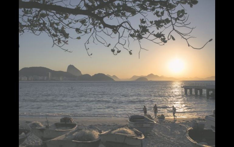 Un grupo de personas se ejercita, mientras disfruta del espectacular amanecer en Copacabana. AP / F. Dana