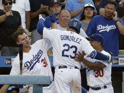 Adrián González (23) es felicitado al llegar al dogout de su equipo. AP / A.Gallardo