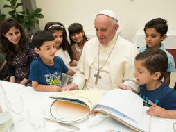 Los niños sirios regalan al Papa Fransico un cuaderno con sus dibujos; a su vez, él les obsequió juguetes. AP / Observatorio Romano