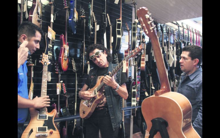 Afinado. Previo a la conferencia, Alex Lora visitó una tienda de música donde probó varias guitarras. EL INFORMADOR / F. González