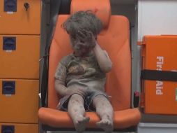 Omran Daqneesh, aparece sentado en una ambulancia tras ser rescatado anoche de una vivienda bombardeada. EFE /