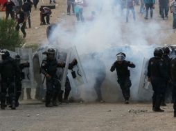 Algunos elementos policiacos fueron atacados y dos fueron rociados con gasolina, amagados con ser quemados vivos. AP / ARCHIVO