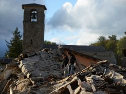 Dos hombres sobre los escombros que dejó el sismo. AFP / F. Monteforte
