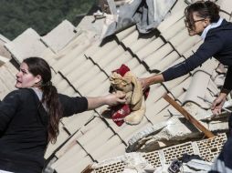 Dos mujeres sostienen un peluche sacado de entre los escombros en Amatrice. EFE / M. Percossi