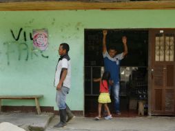Un hombre camina frente a un comercio en Toribio, uno de los muchos municipios afectados durante décadas por el conflicto. EFE / C. Escobar