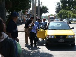 Algunos pasajeros negocian con un taxista par que los traslade por 20 pesos cada uno sobre Pablo Neruda y Terranova. EL INFORMADOR / R. Tamayo