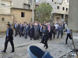 Al Asad, acompañado de una nutrida delegación gubernamental, paseando por las devastadas calles de Daraya. EFE / SANA