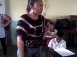 En un video publicado en redes sociales, se ve a una mujer arrebatando libros de texto a alumnos de una escuela primaria. YOUTUBE / Panacleto Medley