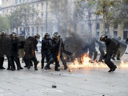 Algunos grupos de encapuchados lanzan bombas molotov contra los granaderos en la Plaza de la República. EFE / E. Laurent