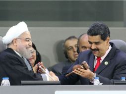 El presidente iraní Hasán Ruhani entrega el martillo de mando al mandatario venezolano, Nicolás Maduro. EFE / P. Miraflores