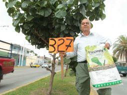 Óscar Hernández posa frente a su árbol 327, una majagua en el camellón de Juan Pablo II, casi en su cruce con Circunvalación. EL INFORMADOR / F. Atilano