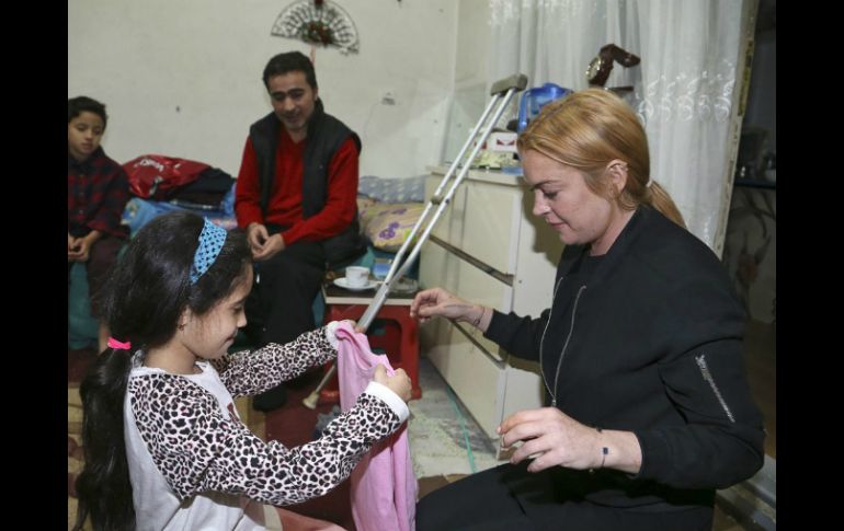 Lindsay Lohan hizo regalos a la familia de refugiados. EFE /