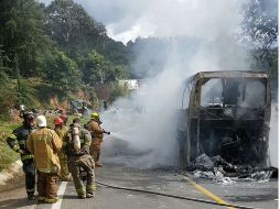 Bomberos apagan el fuego de un autobús de pasajeros. EFE / STR
