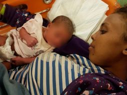 Una mujer observa a su bebé, el cual nació a bordo de una de las embarcaciones, mientras es atendida. EFE / GUARDIA COSTIERA