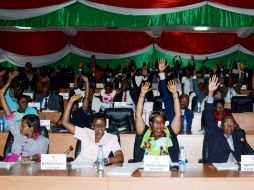 Miembros de la cámara baja del parlamento levantan las manos para votar este 12 de octubre en Buyumbura. AFP / O. Nibigira