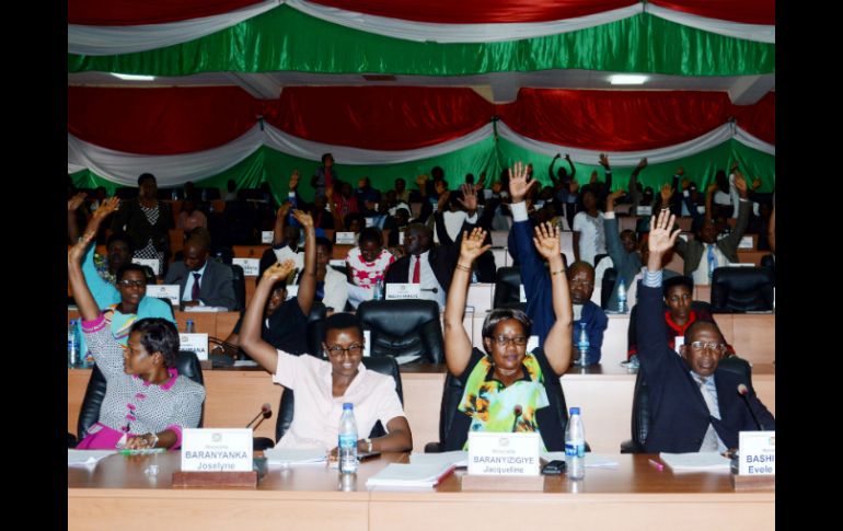 Miembros de la cámara baja del parlamento levantan las manos para votar este 12 de octubre en Buyumbura. AFP / O. Nibigira