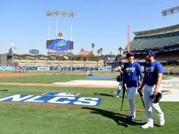 Kenta (I) y Urías (D) inspeccionan el campo donde se llevará a cabo el juego. AFP / H. How