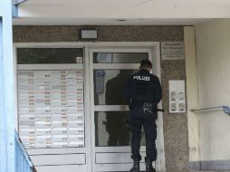 Un policía permanece parado ante el portal de un bloque de viviendas durante una operación antiterrorista en Jena. EFE / B. Schackow