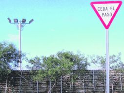 Delante de un muro repleto de cruces irónicamente aparece un anuncio vial con la señal de Ceda el Paso. EL INFORMADOR / ESPECIAL