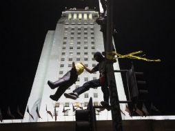 Un manifestante golpea una piñata, que representa a Donald Trump, durante la manifestación. EFE / E. García