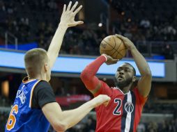 John Wall (2) de Washington intenta una canasta ante Kristaps Porzingis. EFE / M. Reynolds