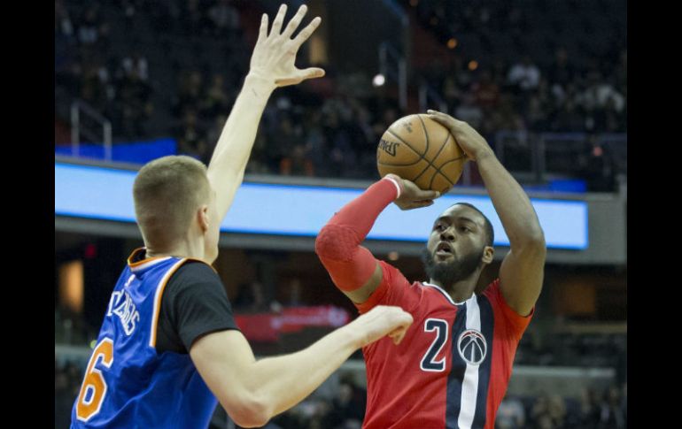 John Wall (2) de Washington intenta una canasta ante Kristaps Porzingis. EFE / M. Reynolds