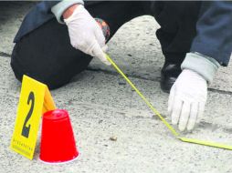 Peritos investigadores analizan una escena de crimen.  /