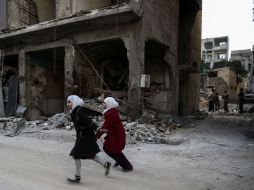 Dos niñas corren por una de las calles afectadas. AFP / S. Al-Doumy