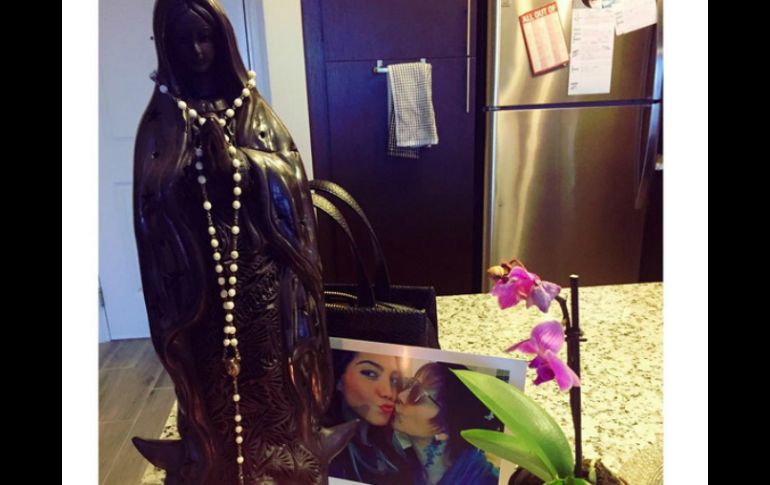 En la imagen aparece una virgen y un rosario, con una foto de ambas de fondo. INSTAGRAM / frida.s.guzman